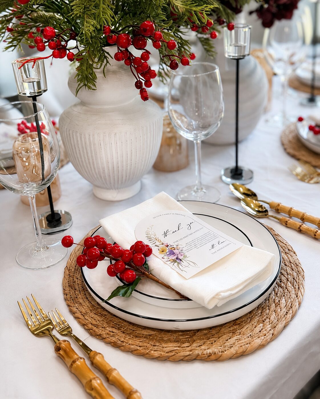 Close place setting with evergreen centerpiece and candlelight