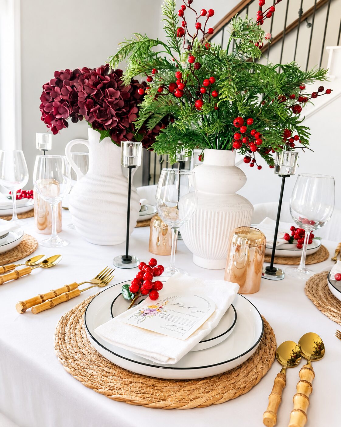 Wide view of elegant tablescape with white ceramic vases and greenery